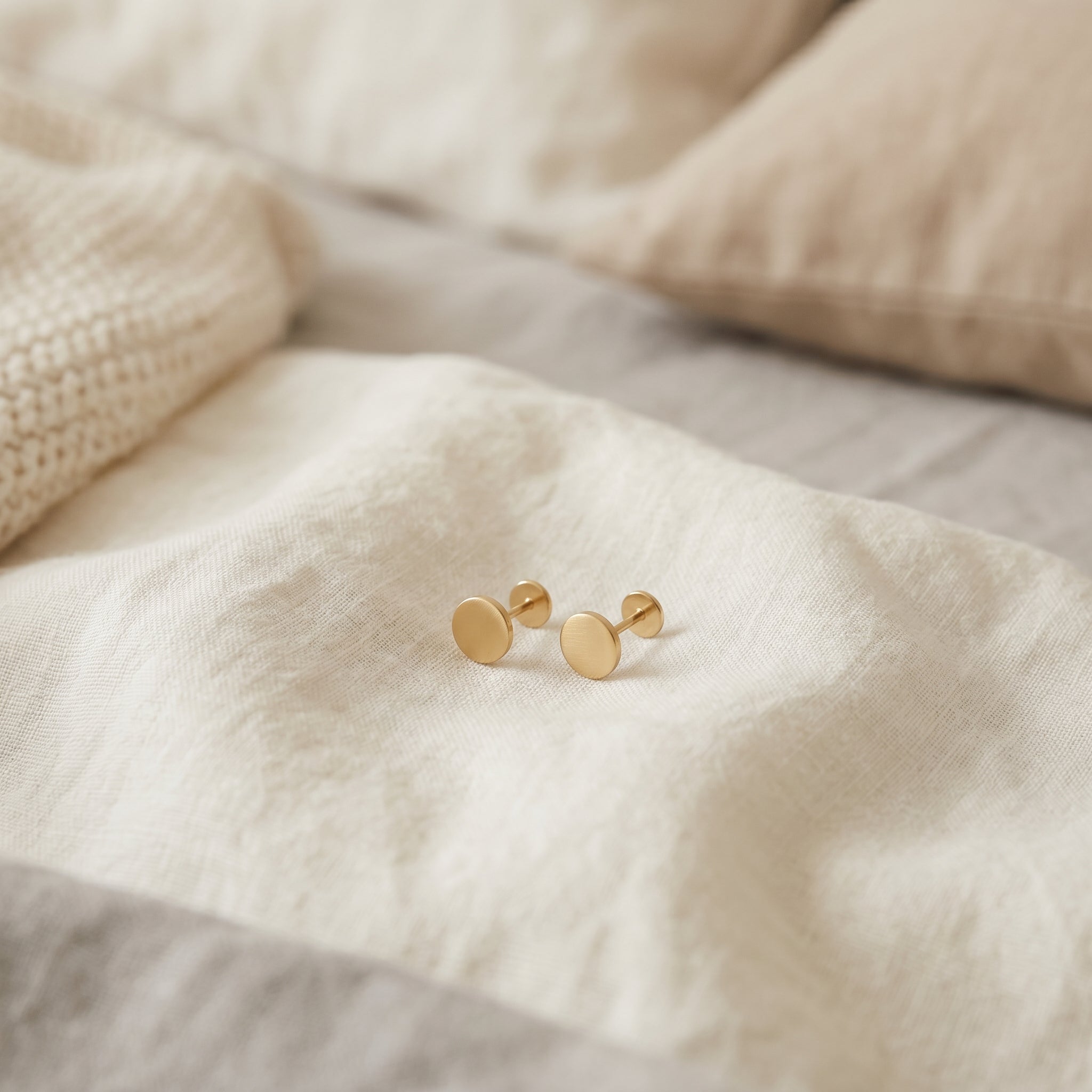 Flat back earrings shown in a minimal setting for a sleep comfort guide.