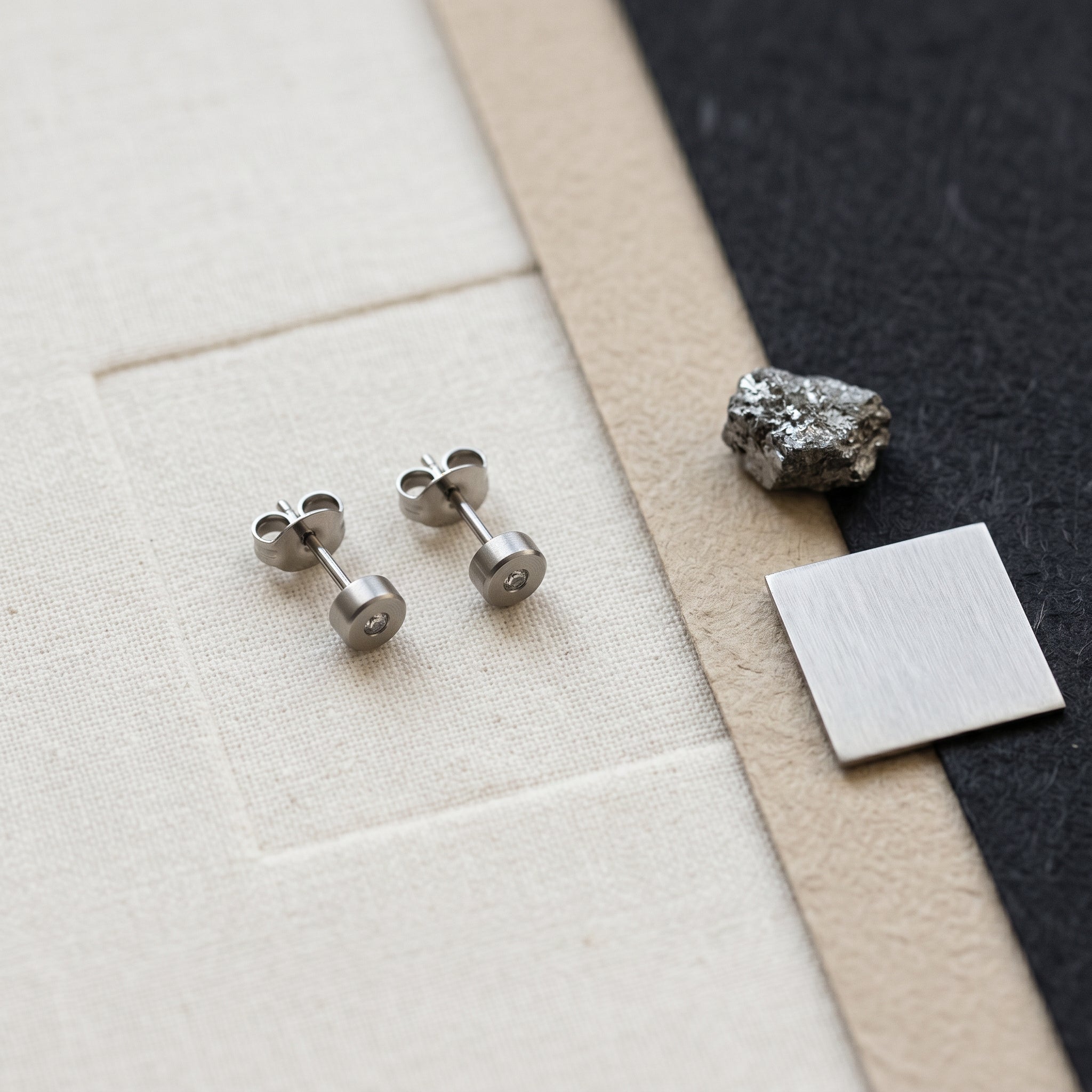 Titanium earrings arranged for an ASTM F136 material guide.